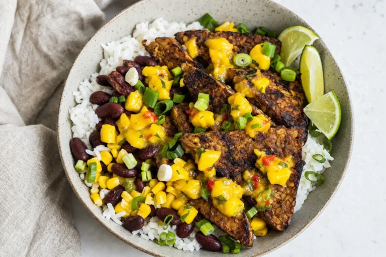 Jerk-Tempeh-Bowl mit Reis, Bohnen, Mais und Mango-Limetten-Sauce